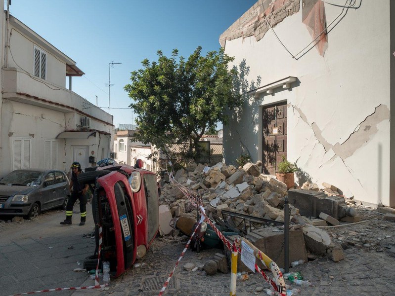 Automobile ribaltata da un grosso blocco murario proveniente dal portico della chiesa adiacente interamente crollato